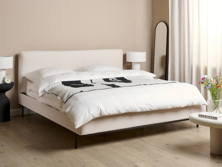 Modern bedroom with a white bed and minimal decor.
