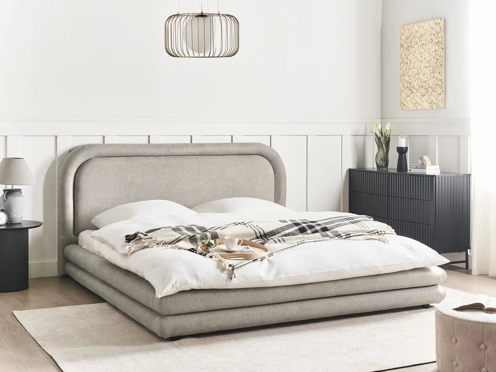 Modern bedroom with a gray upholstered bed and white bedding.