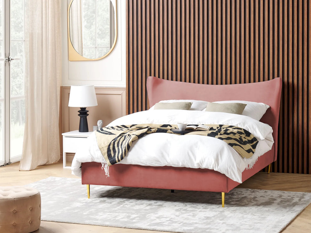 Pink bed with white bedding and a patterned throw in a modern bedroom.