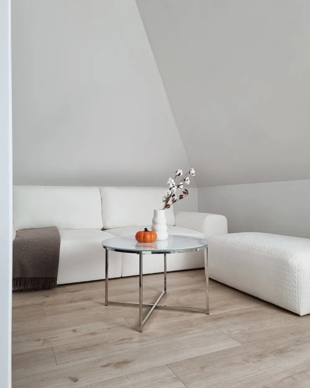 Modern living room with white sofa, coffee table, and decorative items.