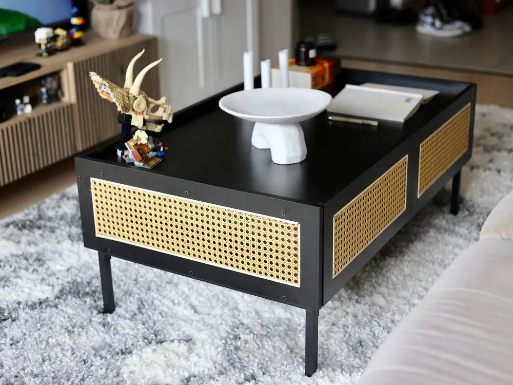 Black coffee table with wicker side panels in a living room setting