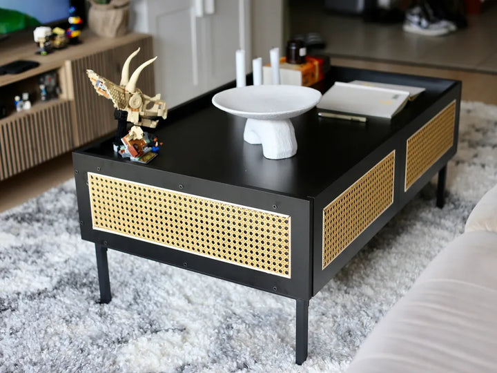 Black coffee table with wicker side panels in a living room setting