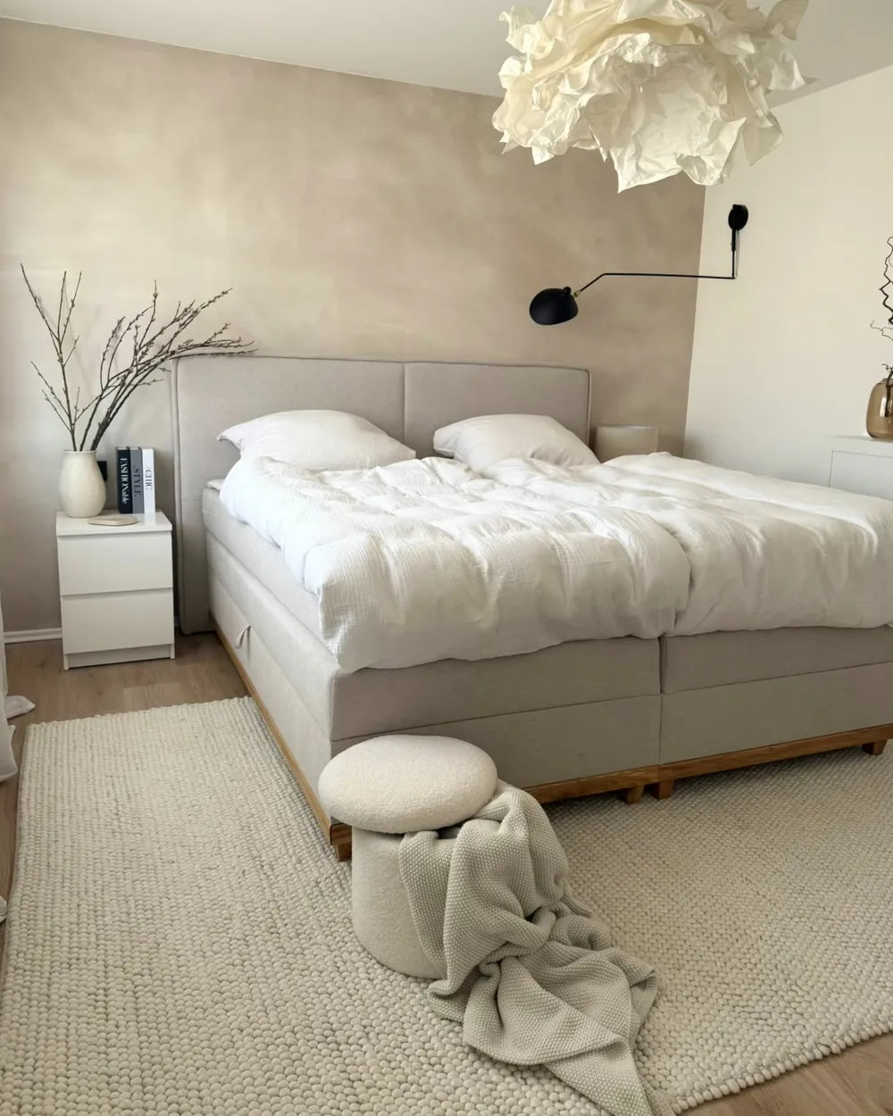 Neatly arranged bedroom with a bed, nightstands, and decorative elements.