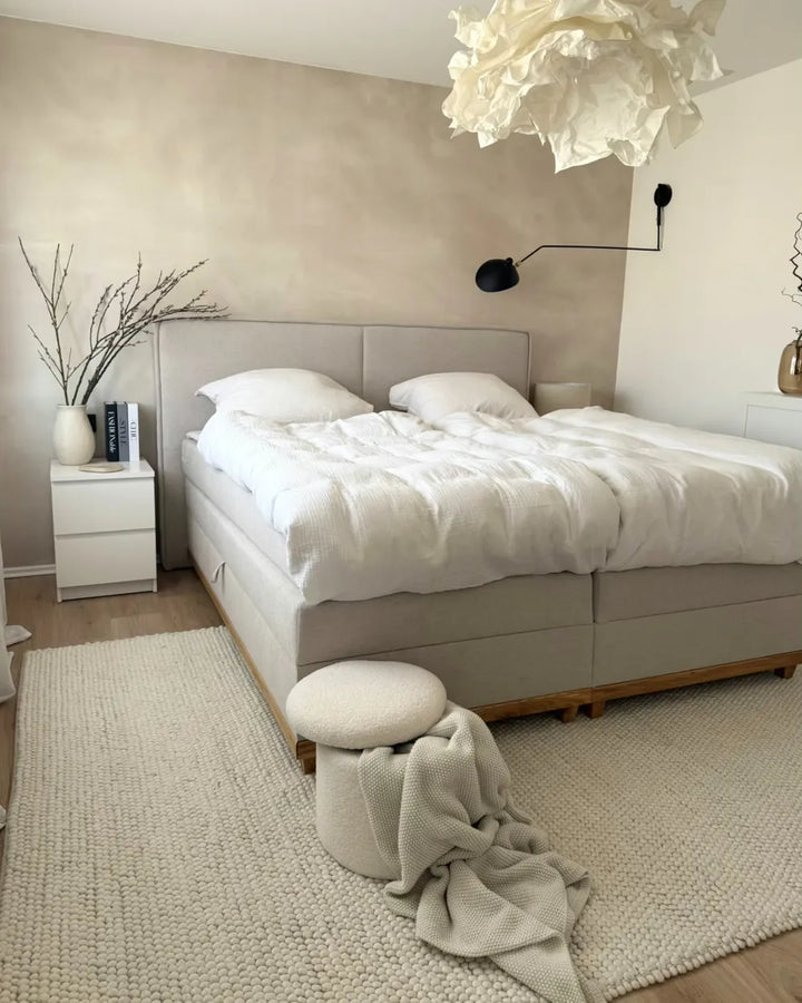 Neatly arranged bedroom with a bed, nightstands, and decorative elements.