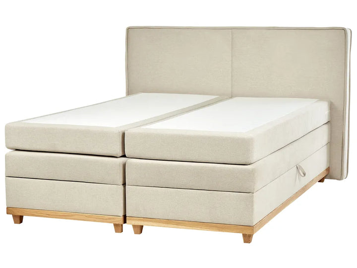 Beige upholstered bed with wooden legs on a white background