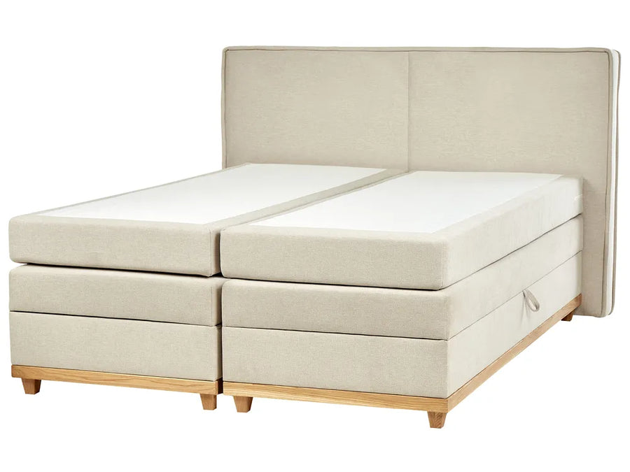 Beige upholstered bed with wooden legs on a white background