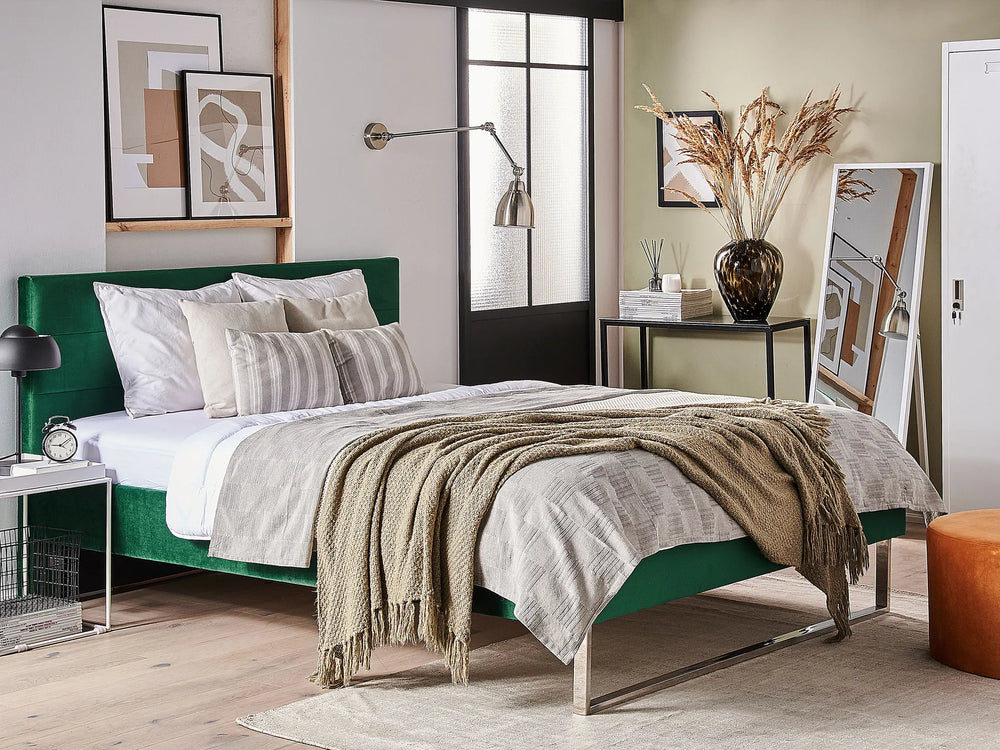 Modern bedroom with a green bed frame, white bedding, and decorative elements.