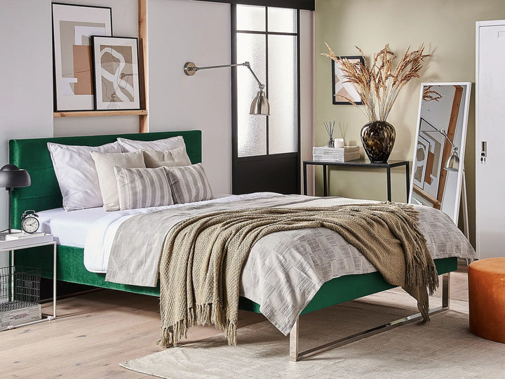Modern bedroom with a green bed frame, white bedding, and decorative elements.