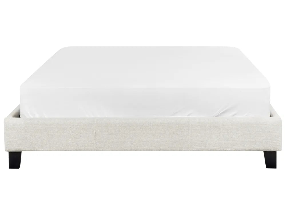 White upholstered bed frame with a mattress on a white background
