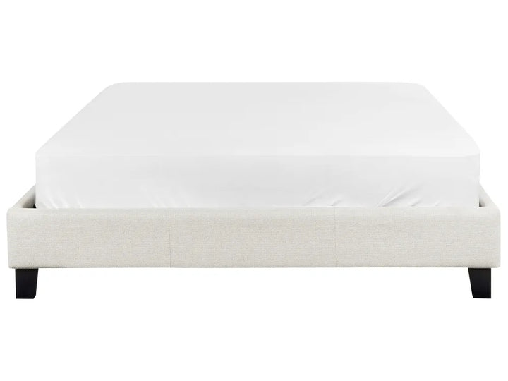White upholstered bed frame with a mattress on a white background