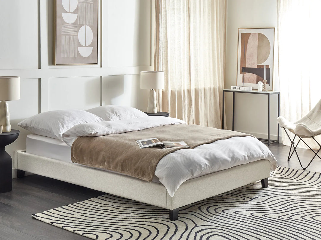 Modern bedroom with a bed, side tables, and abstract art on the wall.