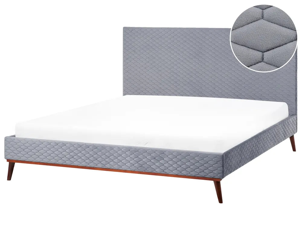 Gray quilted mattress on a bed with a close-up of the mattress pad.