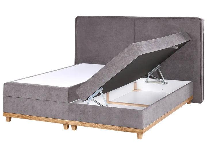 Gray upholstered bed with storage compartment on a white background