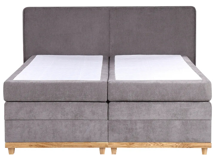 Gray fabric bed with wooden legs on a white background