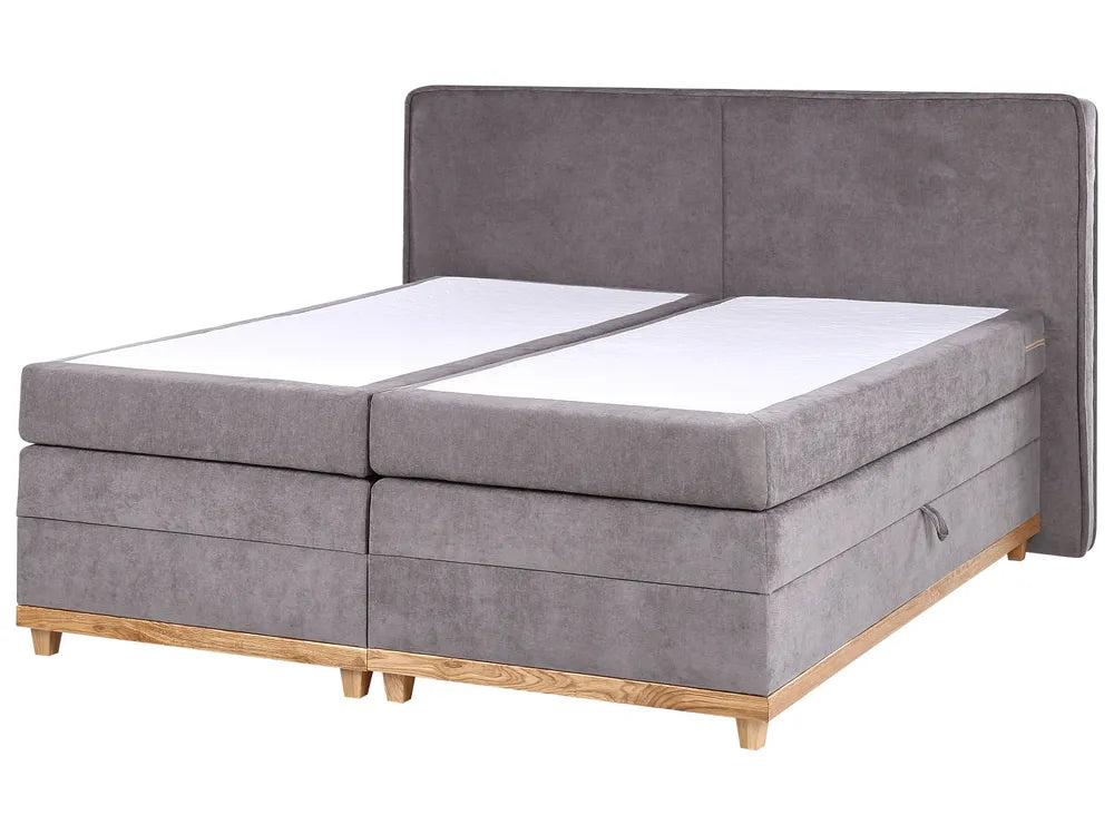 Gray upholstered bed with wooden legs on a white background