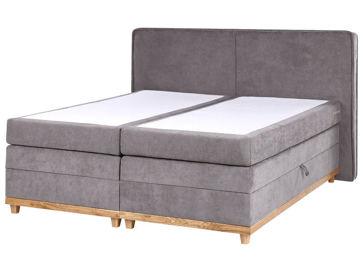 Gray upholstered bed with wooden legs on a white background
