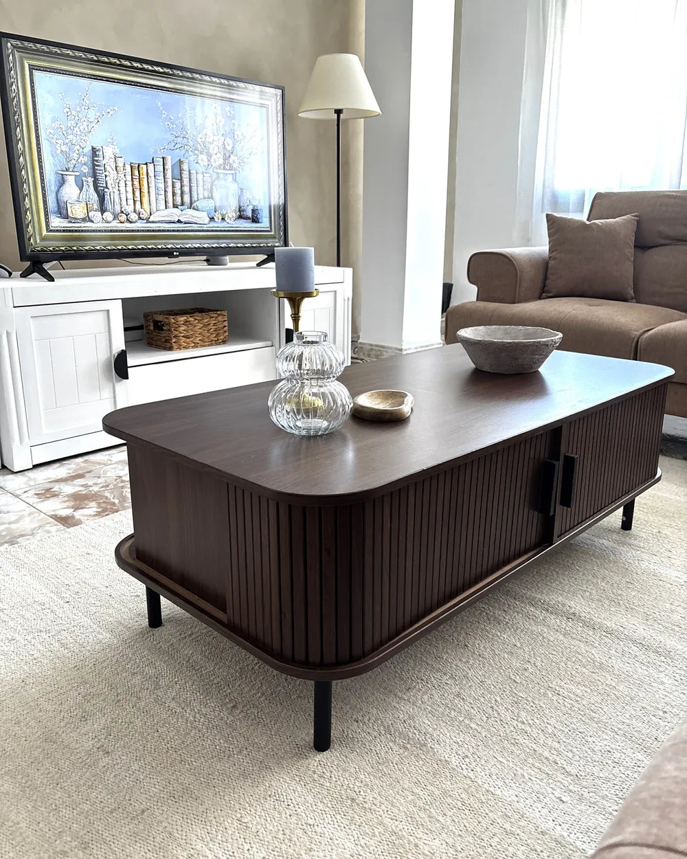 Living room with a dark wooden coffee table, TV, and sofa.