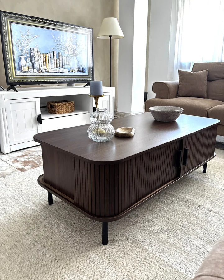 Living room with a dark wooden coffee table, TV, and sofa.