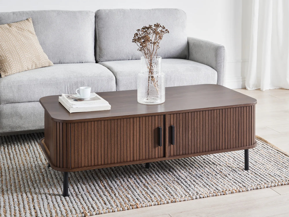 Brown coffee table with decorative items in a living room setting