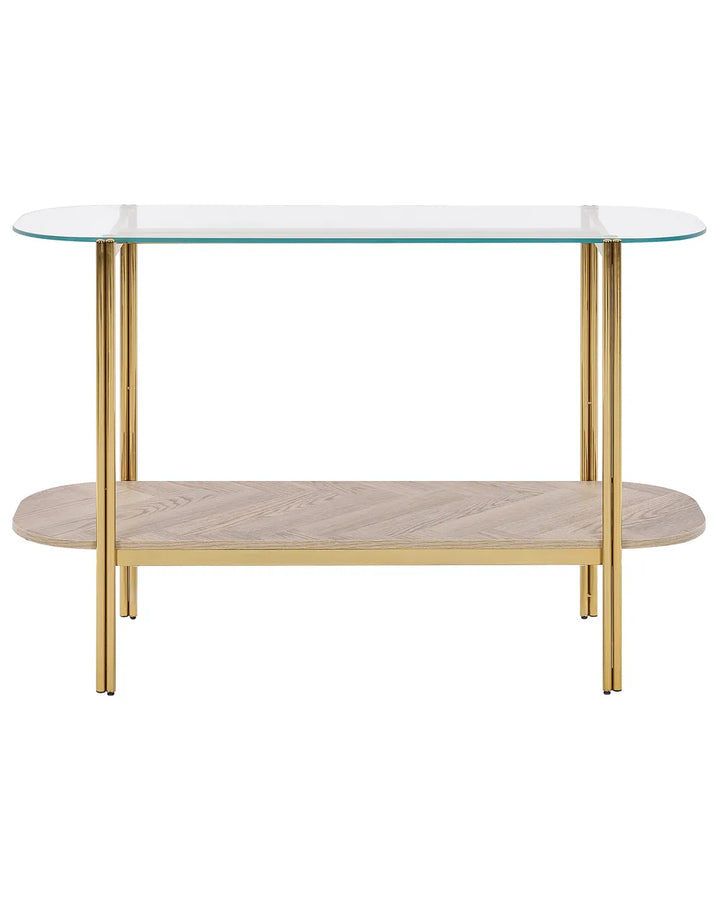 Glass top table with gold legs and wooden shelf on a white background