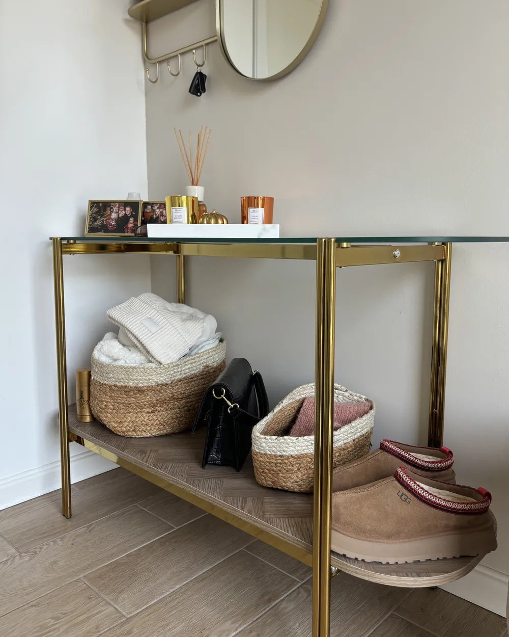 Gold console table with shoes, bags, and decorative items in a room.