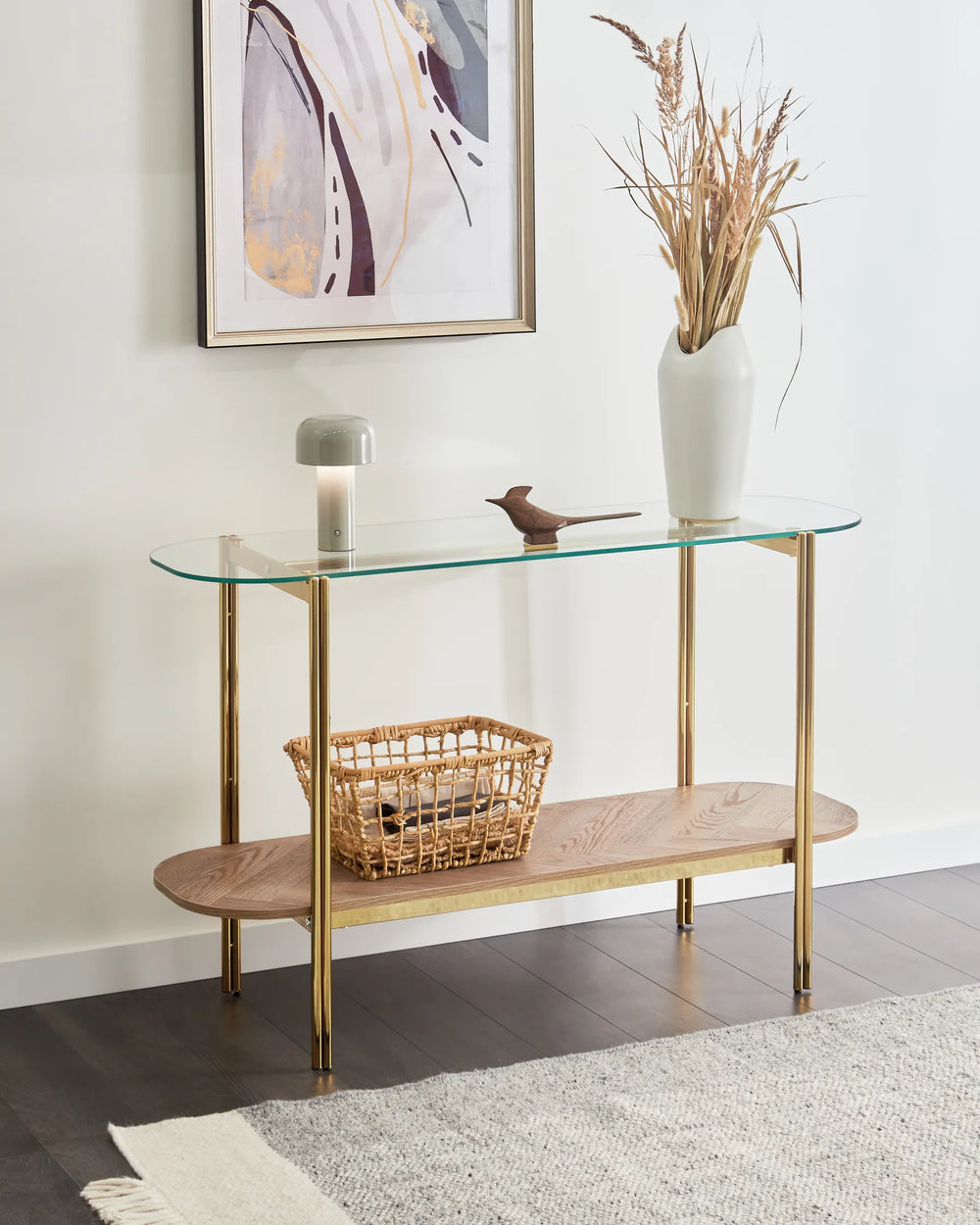 Glass console table with wooden shelf against a white wall