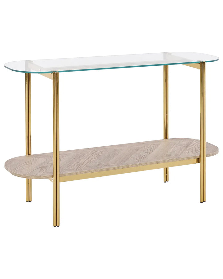 Glass top console table with gold legs and a wooden shelf on a white background