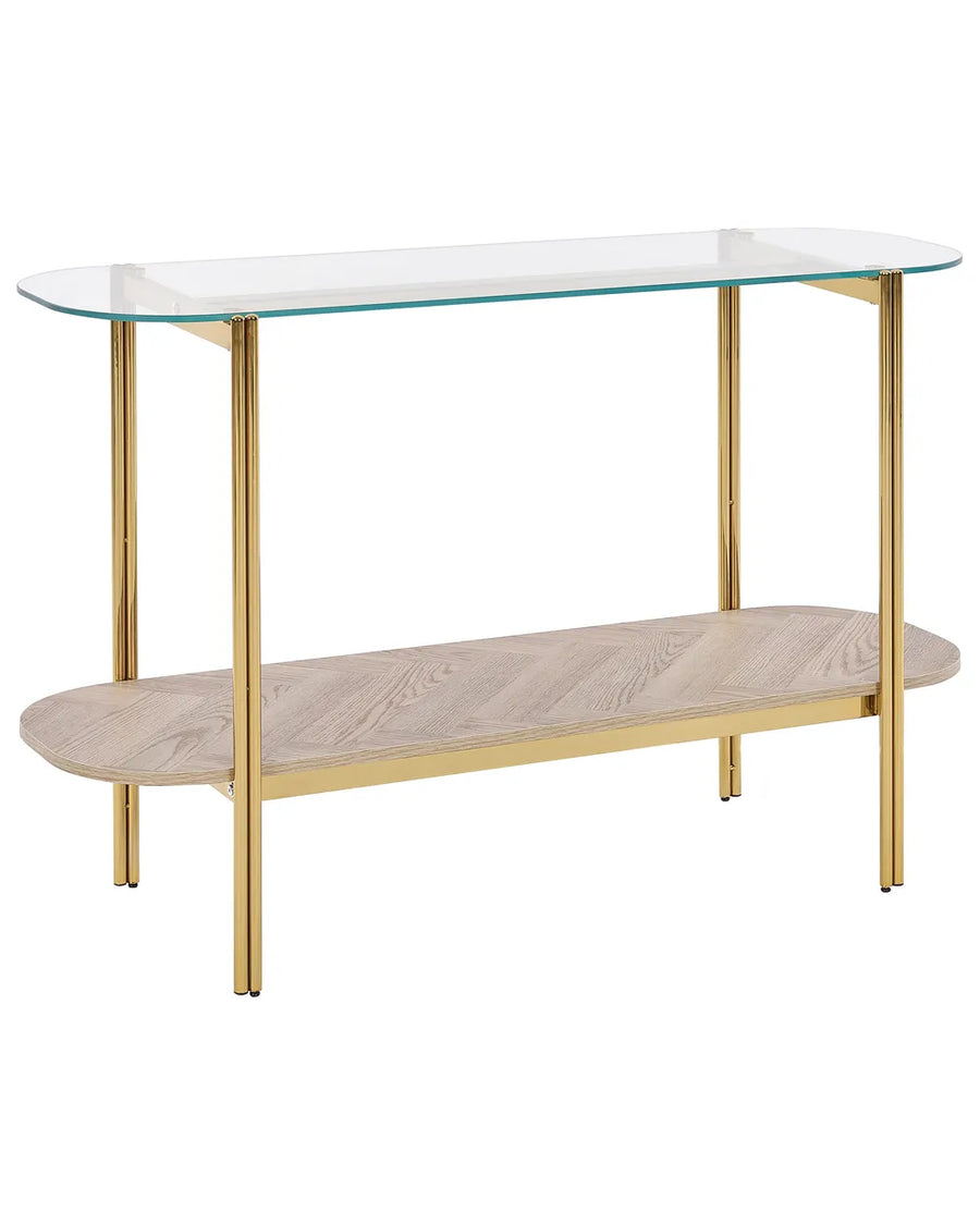Glass top console table with gold legs and a wooden shelf on a white background