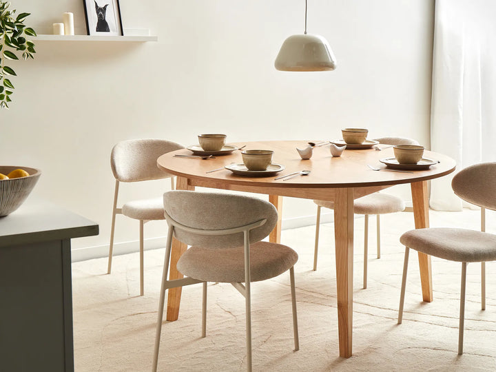 Dining room with a wooden table and chairs in a bright room.