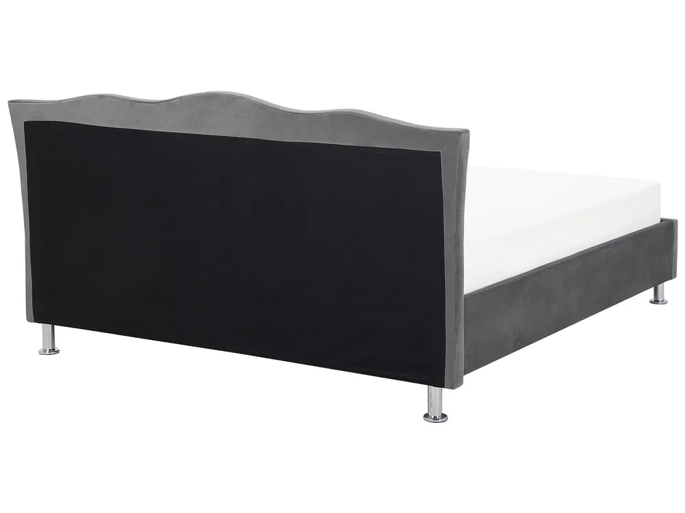 Bed with black upholstered headboard and white mattress on a white background