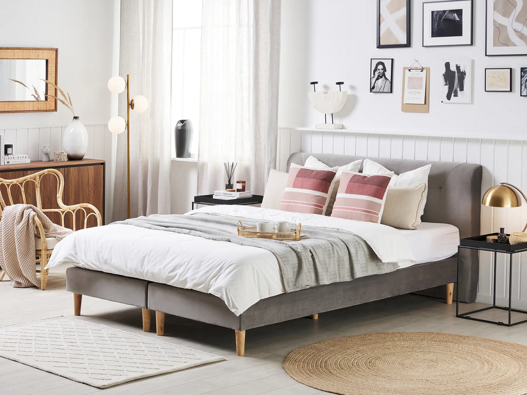 Neatly made bed with striped pillows in a well-decorated bedroom.