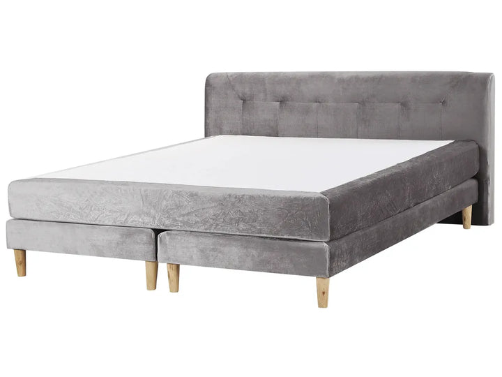 Gray upholstered bed with wooden legs on a white background