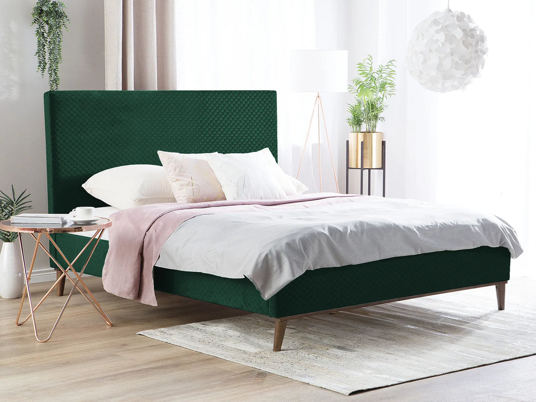 Green bed with white bedding in a bright bedroom
