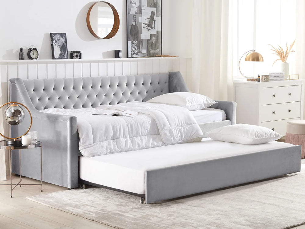 Gray upholstered bed with white bedding in a modern bedroom setting.