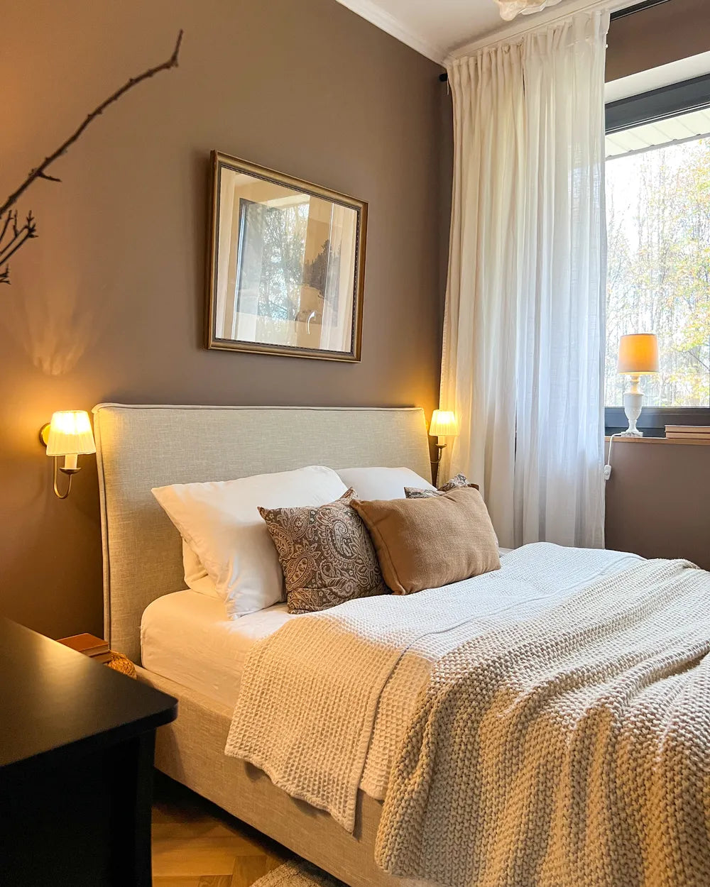 Cozy bedroom with a bed, pillows, and wall art.