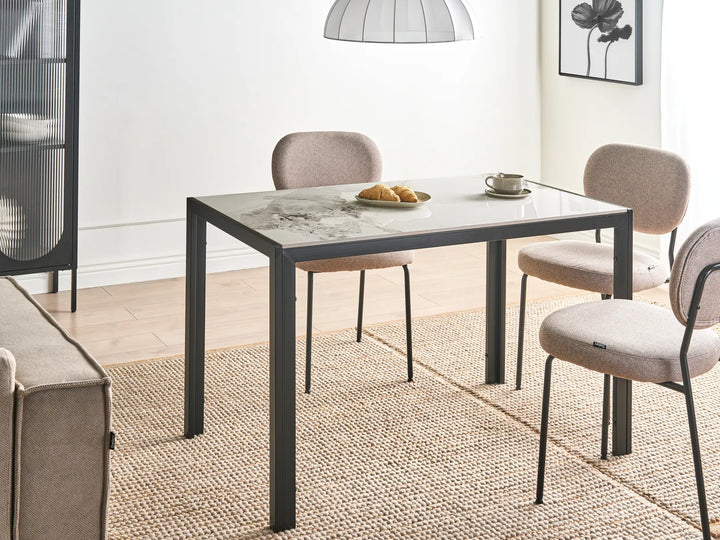 Dining area with a table and chairs in a room with a rug and lamp.
