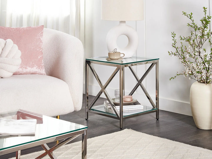 Modern living room with a glass coffee table, side table, and armchair.
