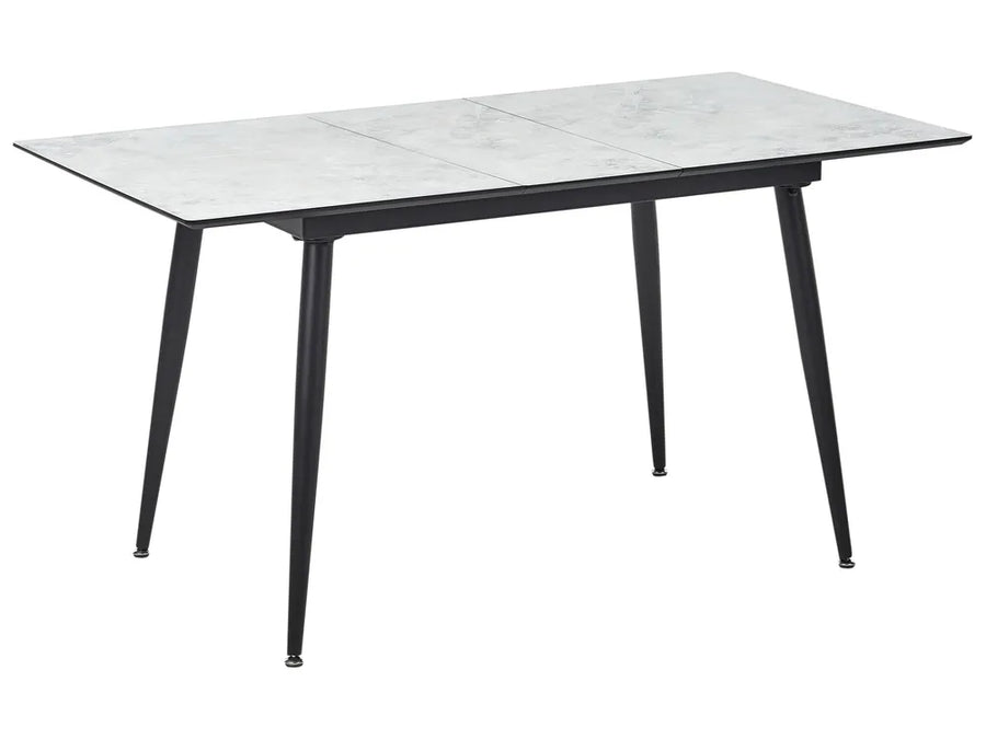 Dining table with marble-like top and black legs on a white background