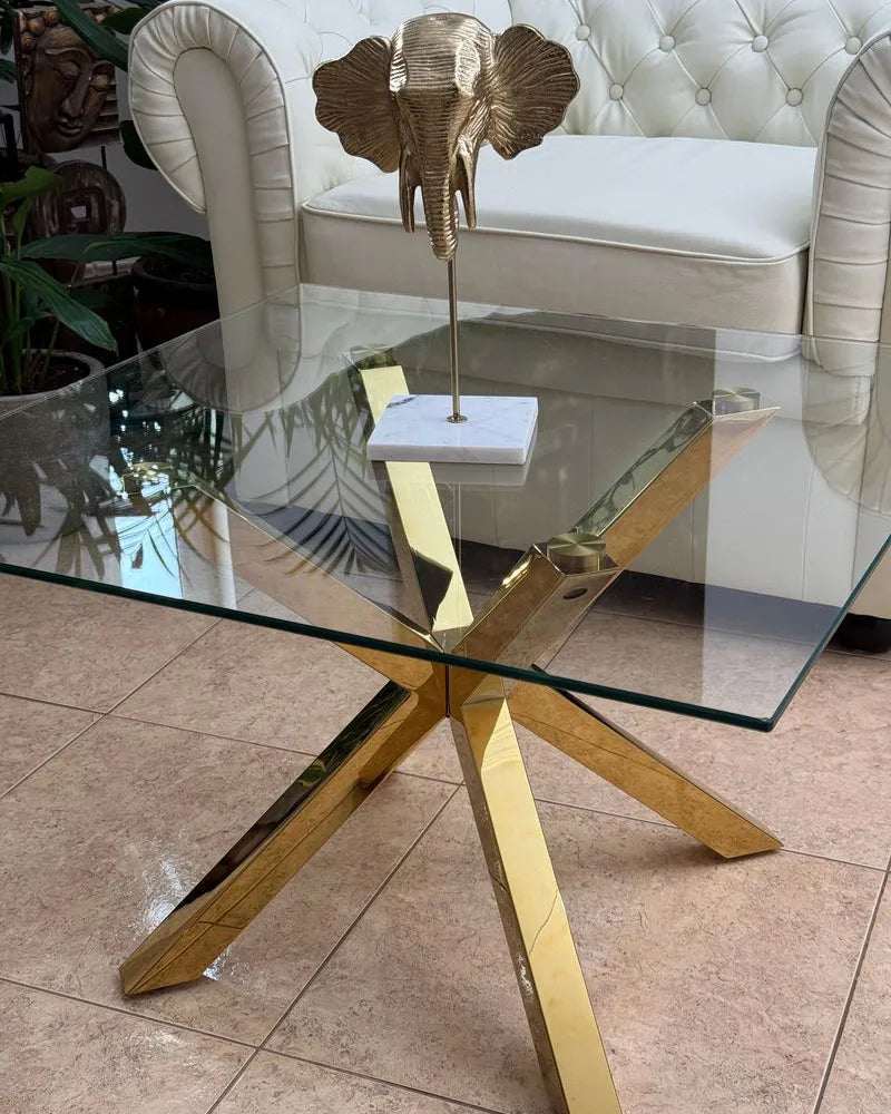 Glass table with gold metal legs in a room setting