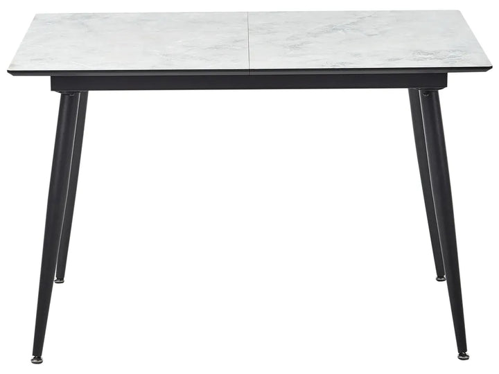 Dining table with marble-like top and black metal legs on a white background
