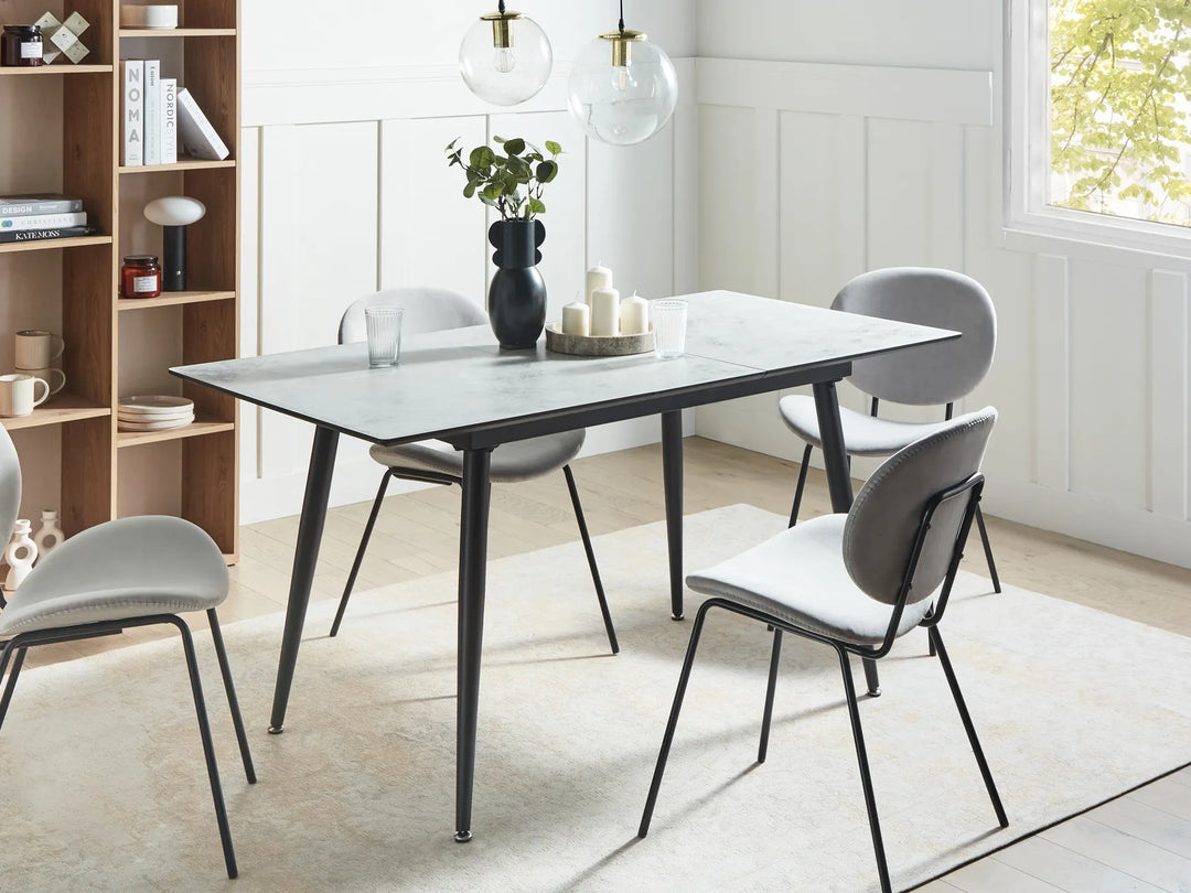 Dining room with a modern table and chairs in a well-lit room.