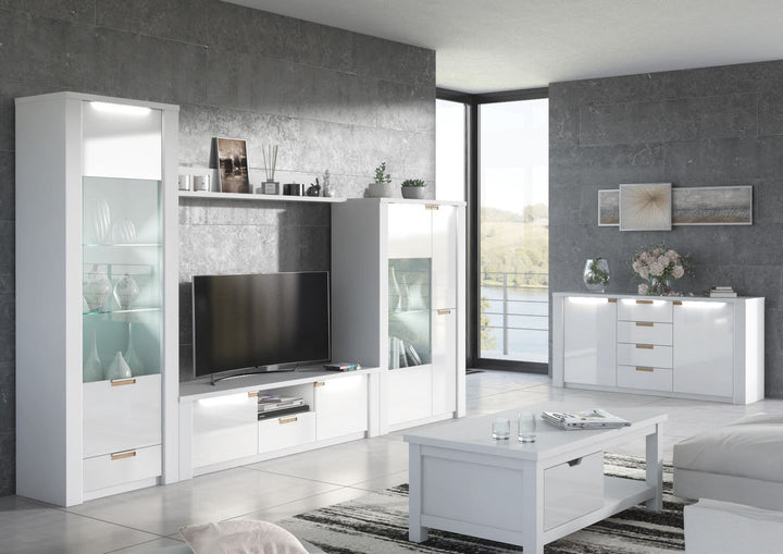 Modern living room with white entertainment unit, TV, and coffee table.
