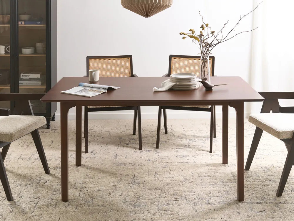 Dining room with a wooden table and chairs on a textured rug.
