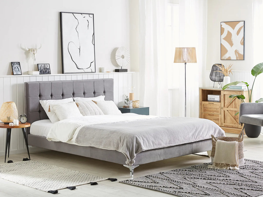 Modern bedroom with a gray upholstered bed, white bedding, and decorative items.