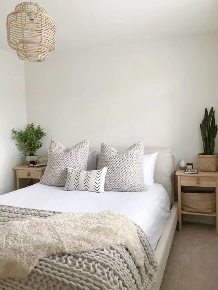 Cozy bedroom with a bed, nightstands, and decorative pillows.