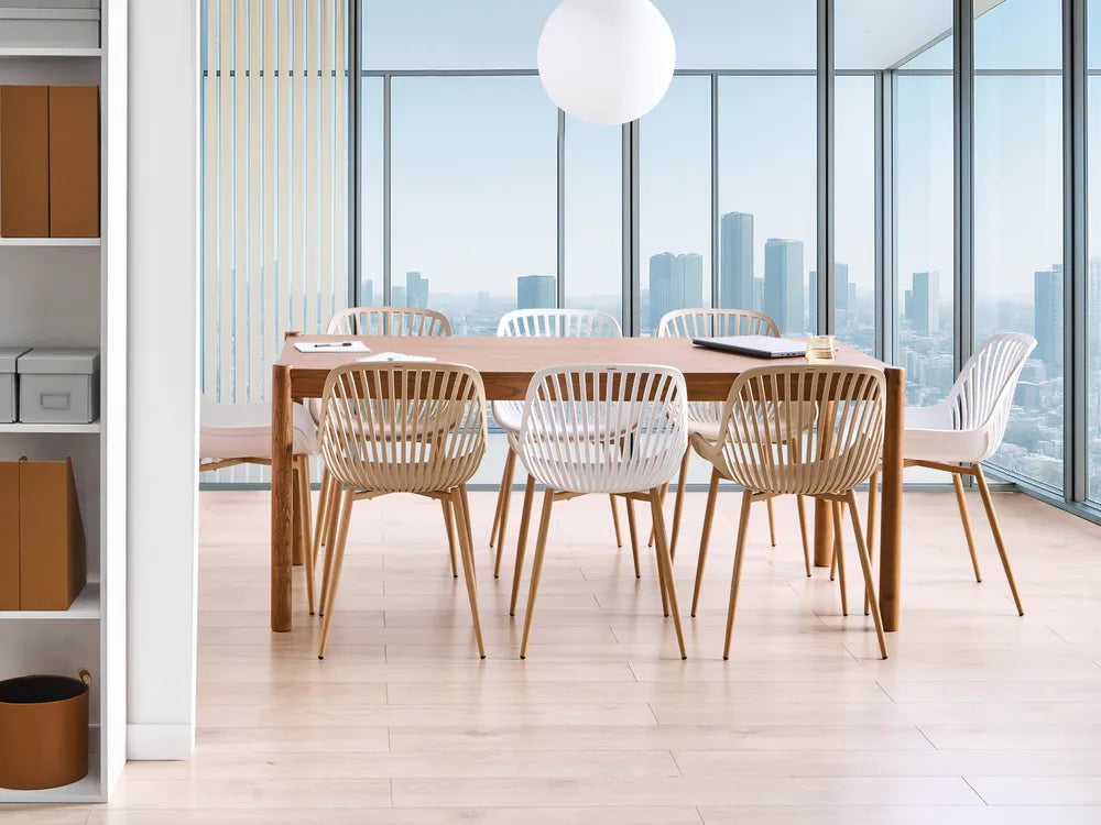 Dining area with wooden table and chairs in a modern office setting with city view.
