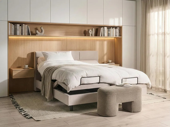 Modern bedroom with adjustable bed, wooden headboard, and built-in shelves.