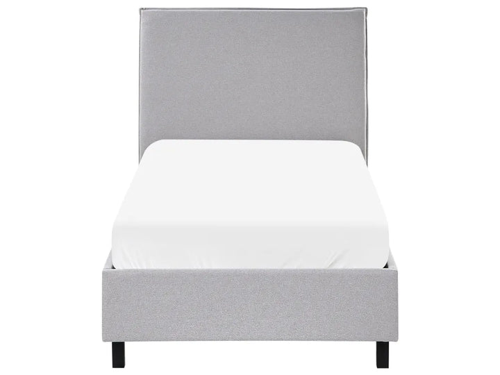 Gray upholstered bed with a white mattress on a white background