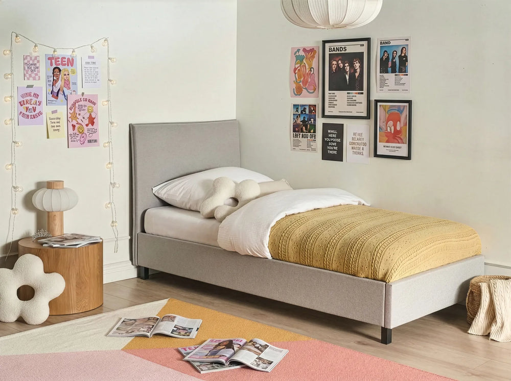 Bedroom with a gray bed, yellow blanket, and posters on the wall.