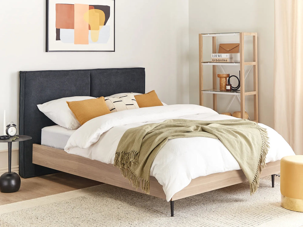 Modern bedroom with a bed, side table, and abstract art on the wall.